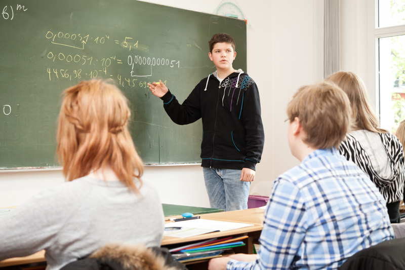 Ein Schüler an der Tafel in einer sehr kleinen Klasse, welches Teil des Konzept der Godesberger Privatschule ist.